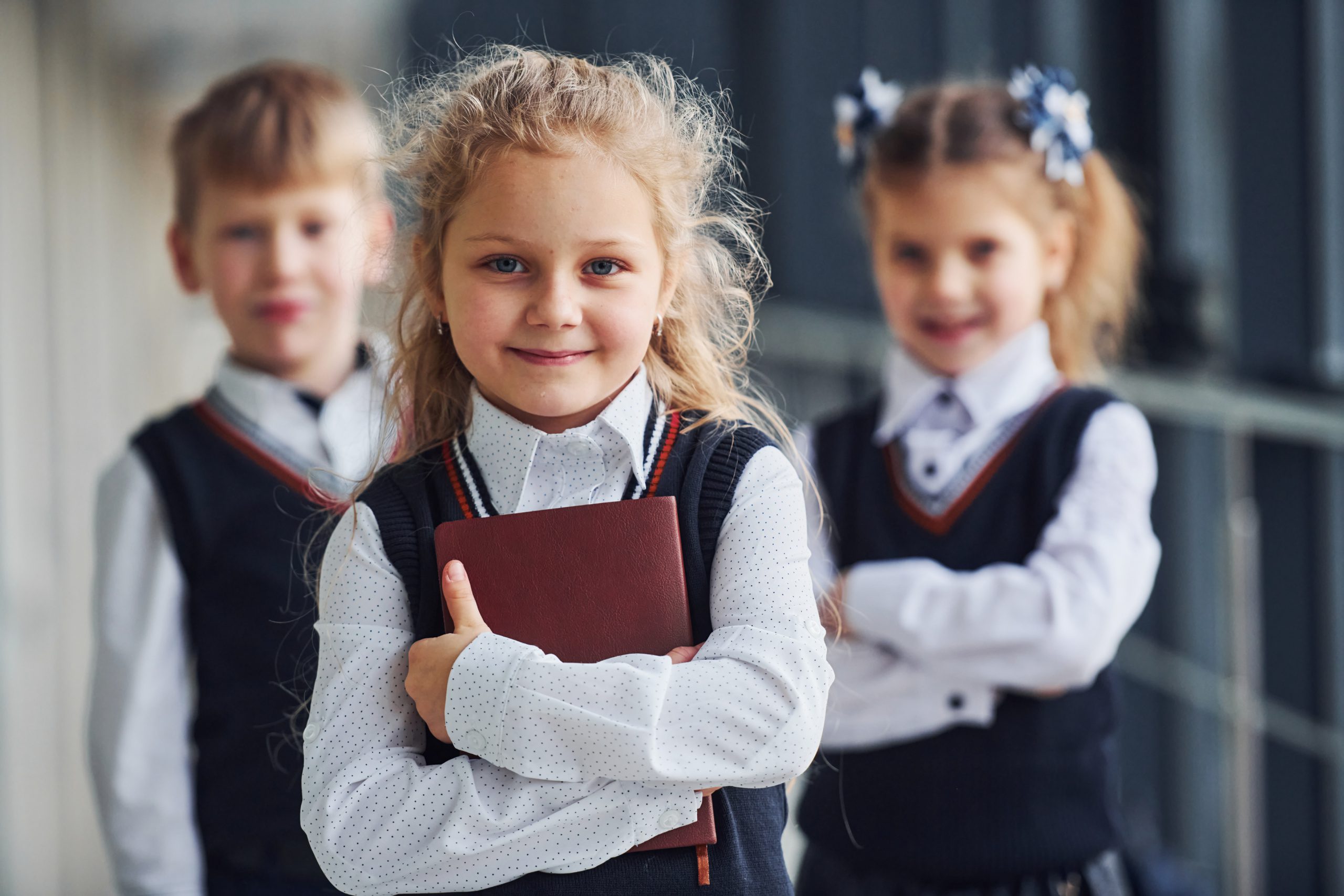 School kids in uniform together with books in corridor. Conception of education